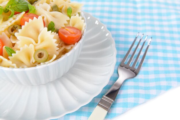 Вкусные макароны с помидорами на тарелке на столе вблизи