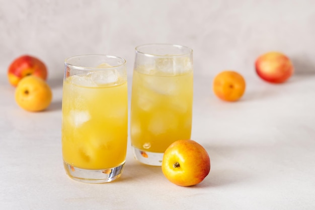 Вкусный персиковый лимонад, приготовленный из содовой воды на сером фоне