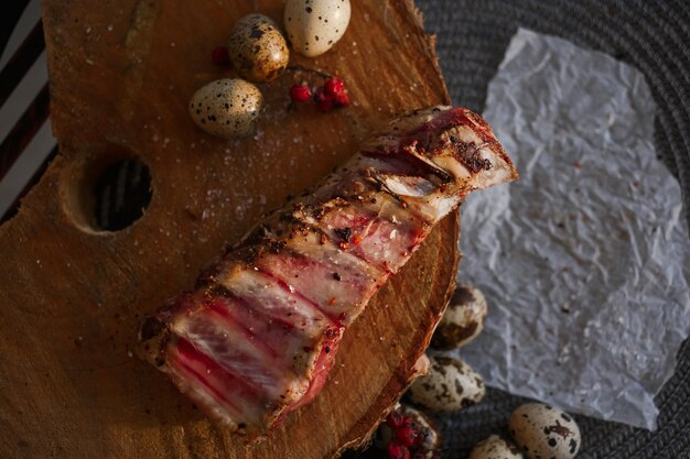 A delicious piece of meat cooked on the grill lies on a wooden board with berries