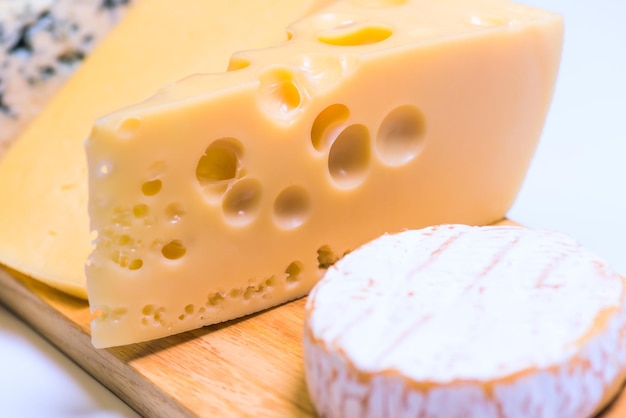 Delicious pieces of different cheese on a white table