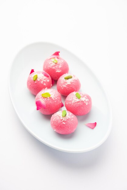 Photo delicious pink chumchum or rose flavour cham cham or rasgulla or rasagola rosogola rosogolla