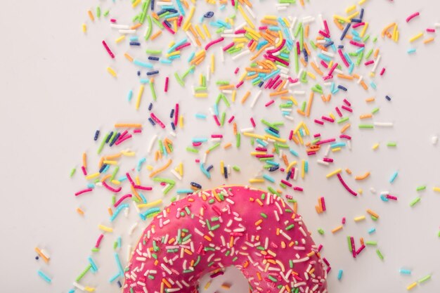 Delicious pink frosted donut with colorful sprinkles