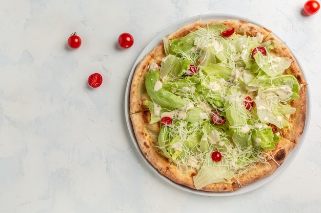 Delicious pizza Caesar with chicken, parmesan, egg, cherry tomatoes and fresh lettuce. banner, menu, recipe place for text, top view.