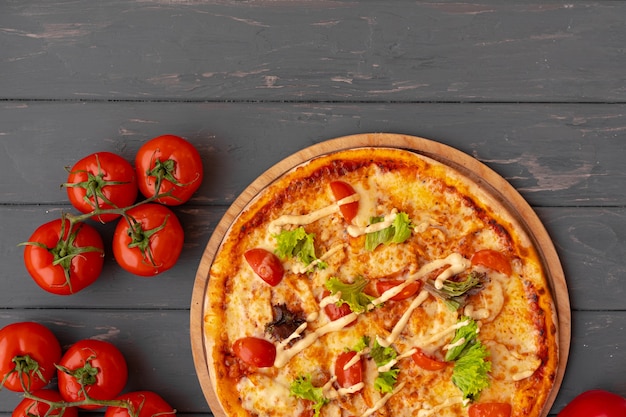 Delicious pizza on gray wooden surface top view