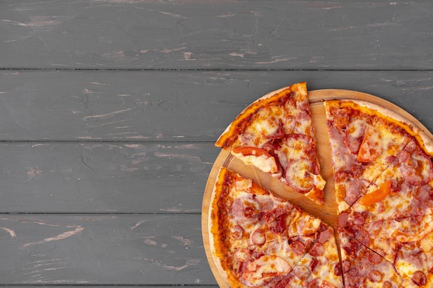 Delicious pizza on gray wooden top view