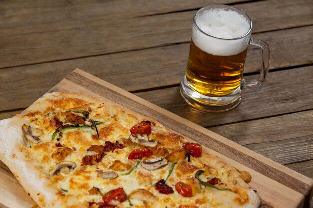 Delicious pizza served on pizza tray with a glass of beer