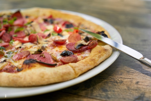 Delicious pizza served on porcelain plate