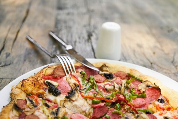 Delicious pizza served on porcelain plate