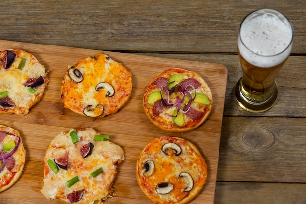 Delicious pizza served on wooden board with a glass of beer