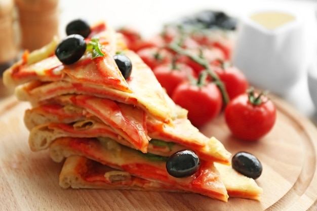 Delicious pizza slices on wooden cutting board