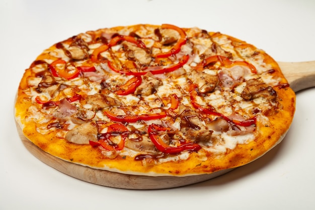 Delicious pizza with bacon and chicken Teriyaki served on a wooden plate, ingredients Signature sauce, mozzarella cheese, Teriyaki chicken, bacon, Bulgarian pepper, Teriyaki sauce on white.