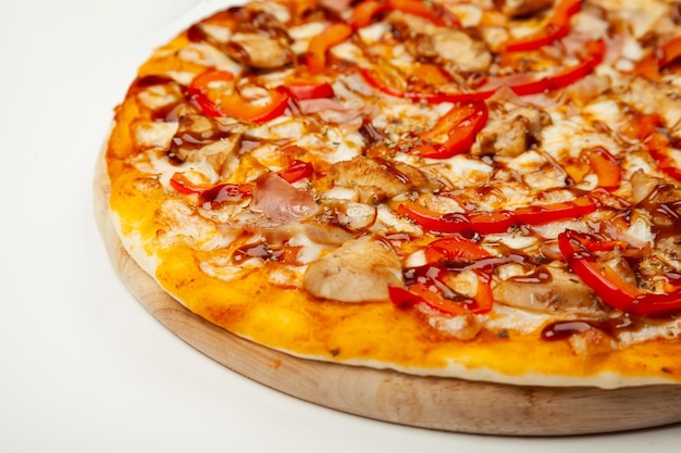 Delicious pizza with bacon and chicken Teriyaki served on a wooden plate, ingredients Signature sauce, mozzarella cheese, Teriyaki chicken, bacon, Bulgarian pepper, Teriyaki sauce on white.