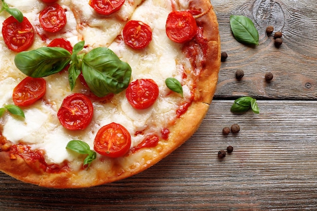 Delicious pizza with cheese and cherry tomatoes on wooden table top view