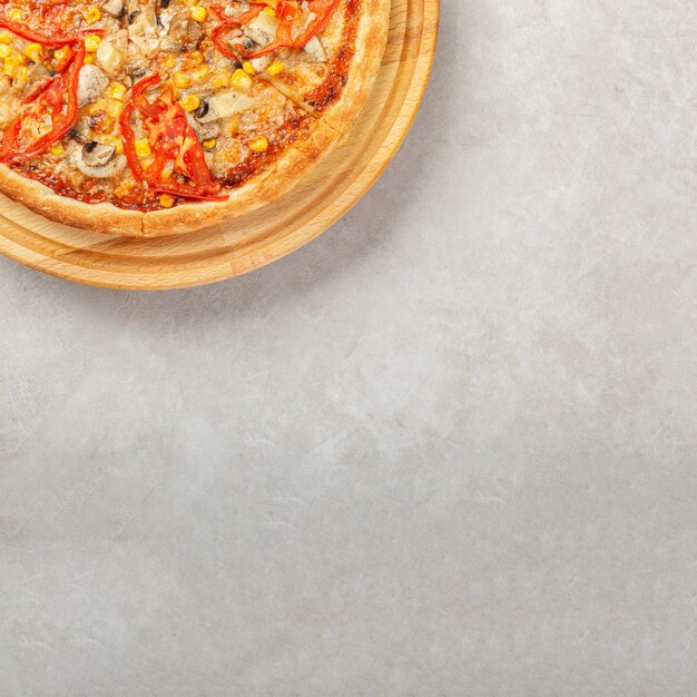 Фото Вкусная пицца с куриными грибами, сыром, помидорами и кукурузой на бетонном фоне
