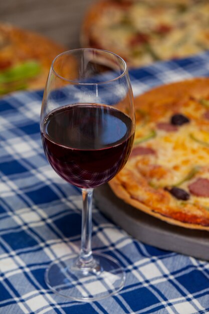 Deliziosa pizza con un bicchiere di vino rosso