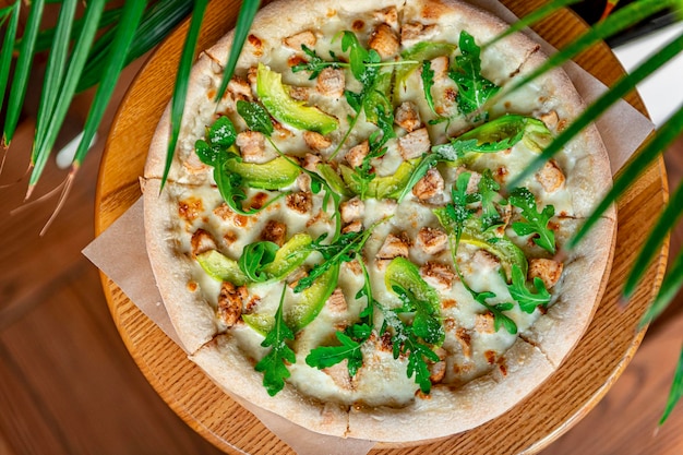 Delicious pizza with grilled chicken avocado and arugula