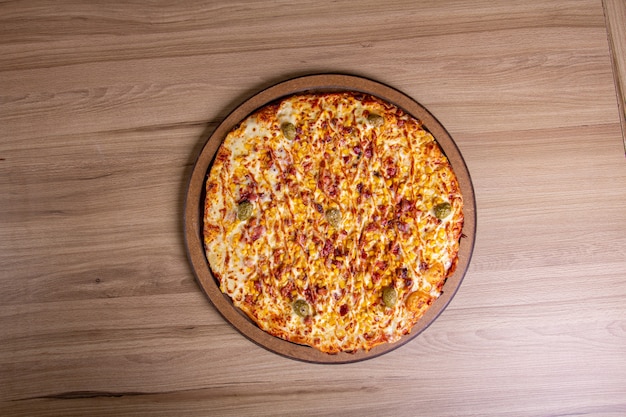 Delicious pizza with lots of filling on a wooden table