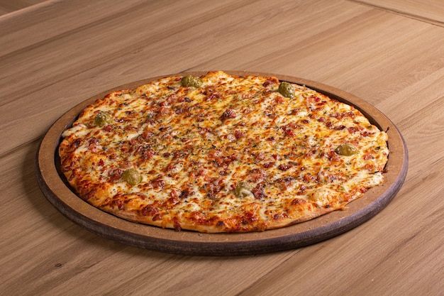 Delicious pizza with lots of filling on a wooden table
