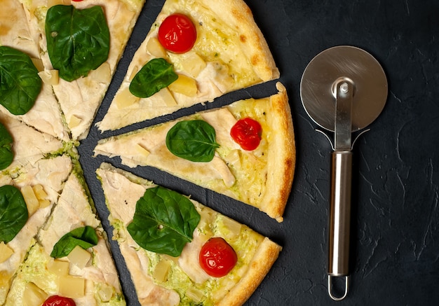 delicious pizza with pineapple, tomatoes, mozzarella cheese, chicken fillet on a stone background