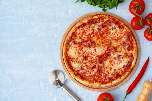 Delicious pizza with sausages on gray background