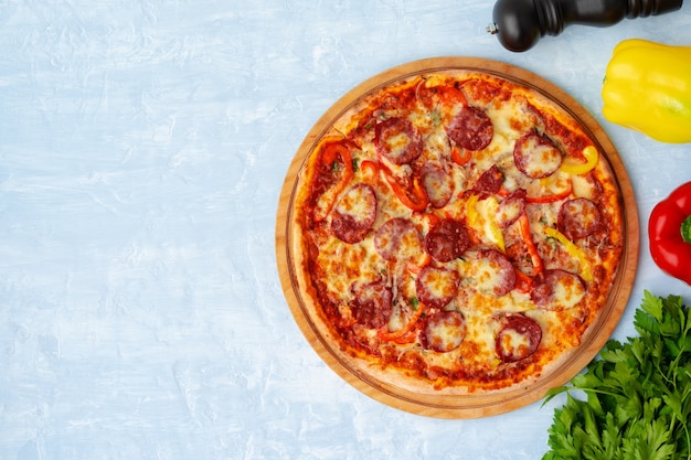 Delicious pizza with sausages on gray background