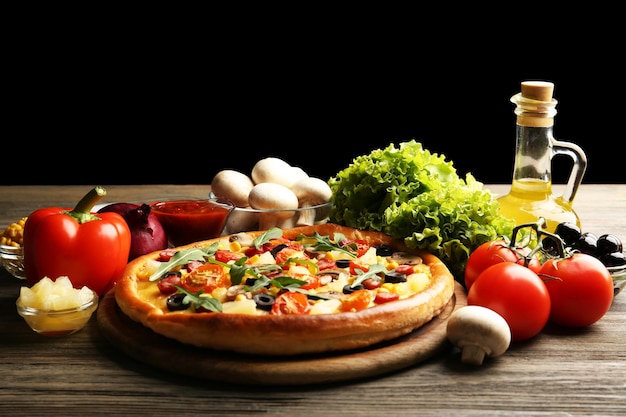 Photo delicious pizza with vegetables on black background