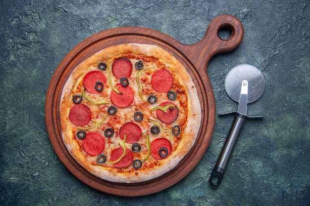 Delicious pizza on wooden cutting board on isolated dark surface