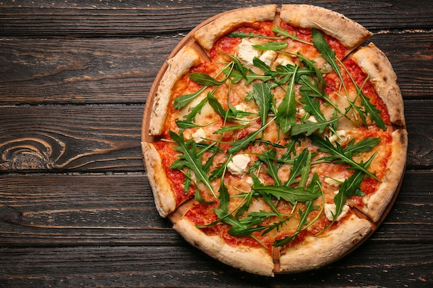 Delicious pizza on wooden table, top view