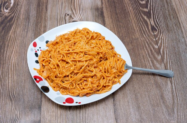 Delicious plate of spaghetti on wooden table