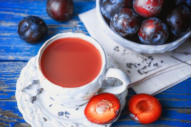 Delicious plum juice with fruits on wooden table close up