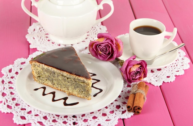 Delicious poppy seed cake with cup of coffee on table closeup