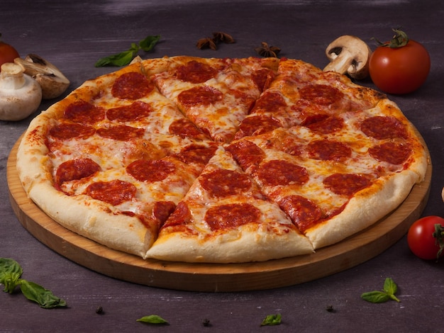 Delicious and popular pepperoni pizza on a wooden board