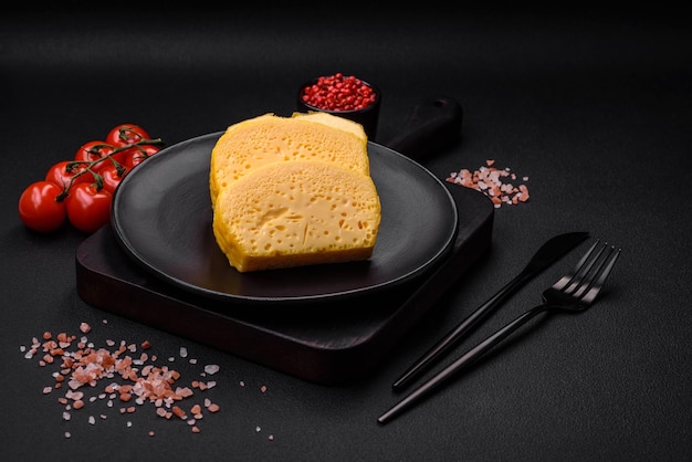 세라믹 접시에 큰 조각으로 자른 맛있는 다공성 노란색 치즈
