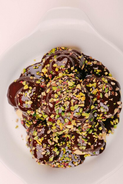 Delicious profiteroles with chocolate on the table