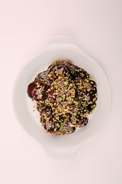 Delicious profiteroles with chocolate on the table