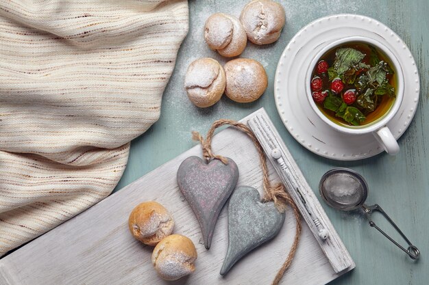 Delicious profiteroles with whipped cream and two decorative wooden hearts