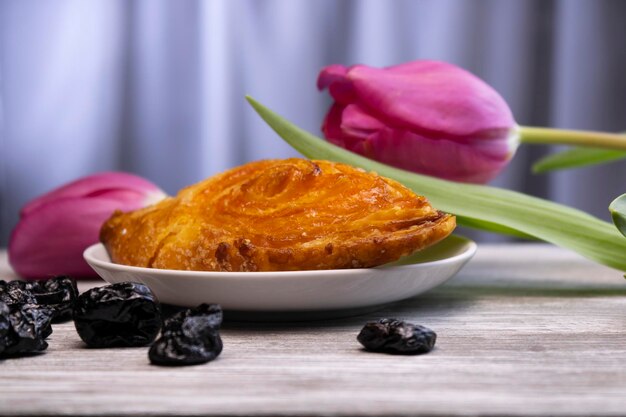 Deliziosa pasta sfoglia con tulipani lilla e prugne sullo sfondo