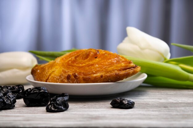 흰색 튤립과 자두가 배경에 있는 맛있는 퍼프 페이스트리