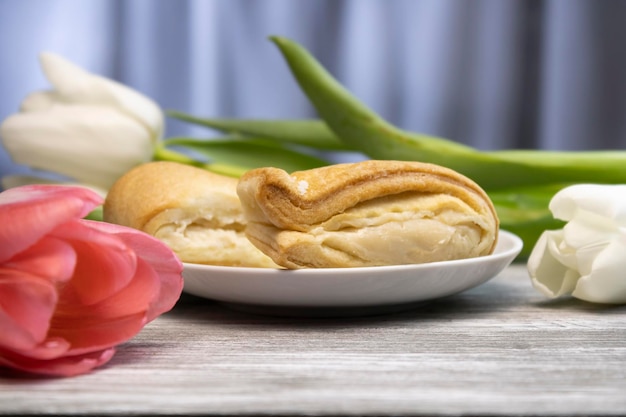 Delicious puff with white and pink flowers in the background closeup