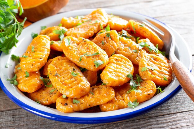 Delicious pumpkin gnocchi with olive oil, vegan food. Autumn meal.