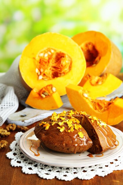 Delicious pumpkin pie on plate on wooden table on natural background