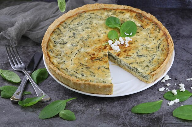 Foto deliziosa torta di quiche con formaggio cottage e ripieno di spinaci