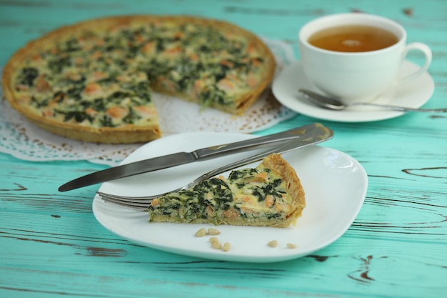 Delicious Quiche pie with salmon fish and pine nuts filling Breakfast with quiche and cup of tea