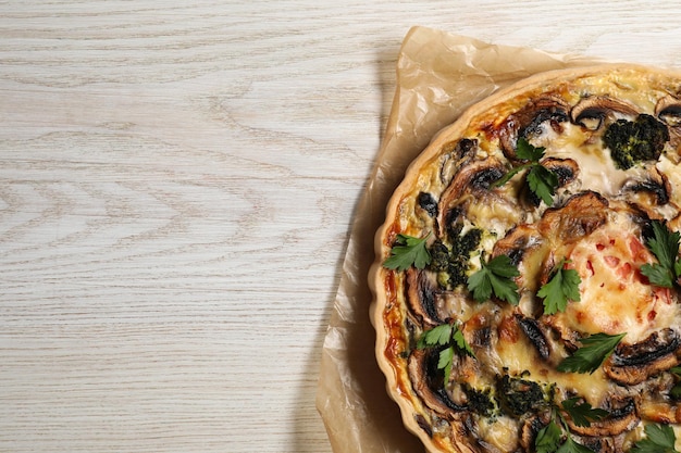 Delicious quiche with mushrooms and parsley on white wooden table top view Space for text