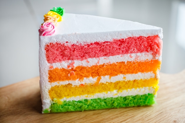 Photo delicious rainbow cake on wood plate.