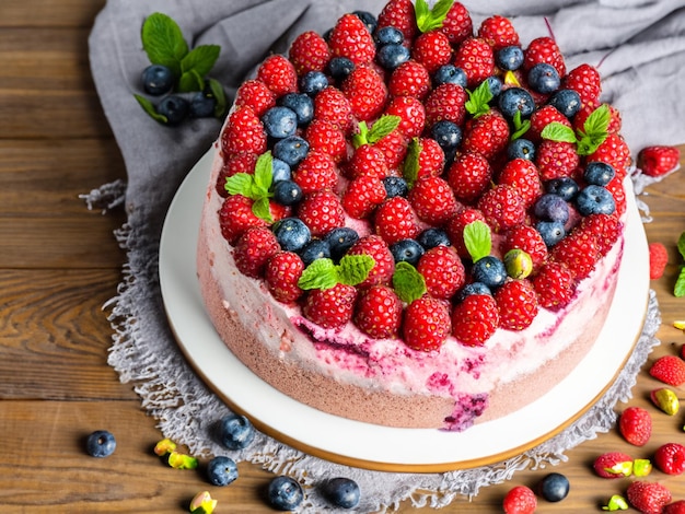 Delicious raspberry cake with fresh strawberries raspberries blueberry currants and pistachios