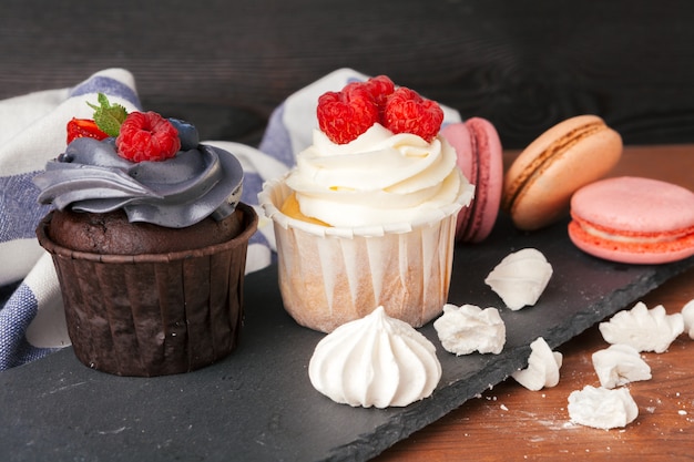 Delicious raspberry and caramel cupcakes on dark 