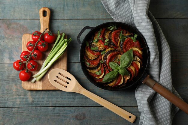 Delicious ratatouille and ingredients on light blue wooden table flat lay