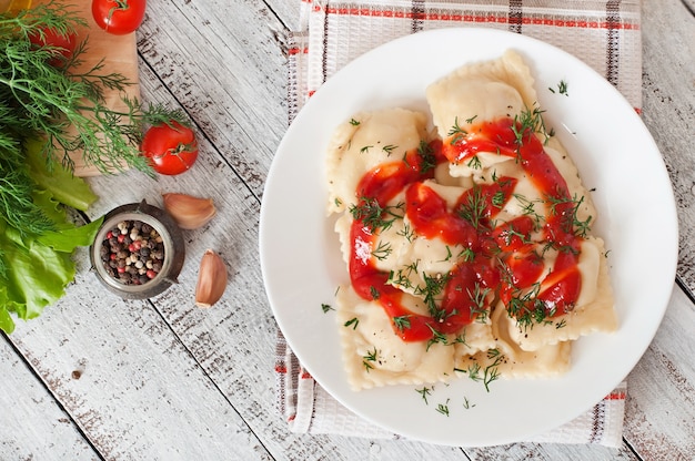 Delicious ravioli with tomato sauce and dill