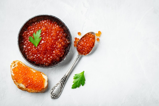 Delicious red caviar in black bowl. copyspace